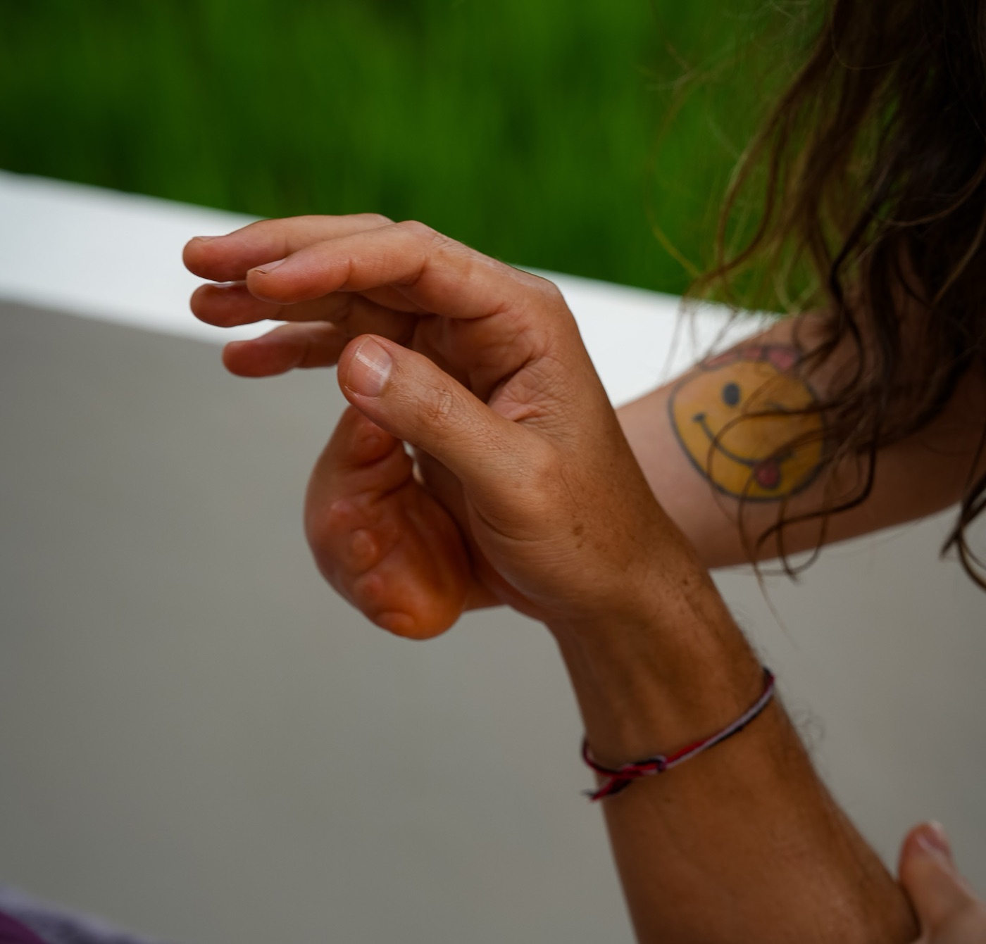 A practitioner's hands working on a client's forearm